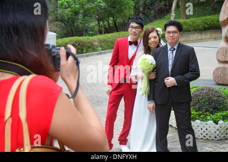 Hong Kong China,HK,Asia,Chinese,Oriental,Island,Central,Hong Kong Park,wedding photographer,photos,bride,groom,posing,red suit,dress,Asian man men mal Stock Photo