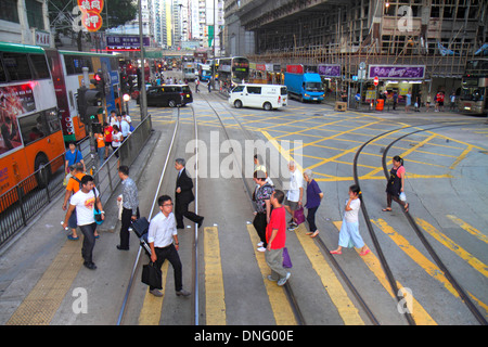 Hong Kong China,HK,Asia,Chinese,Oriental,Island,Wan Chai,Hennessy Road,businesses,district,crossing street,tram,Asian woman female women,man men male, Stock Photo