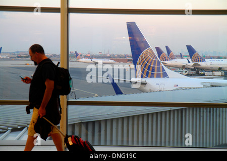 Newark New Jersey,NJ,Newark Liberty International Airport,EWR,terminal,gate,tarmac,window,United Airlines,airliners,parked,man men male,checking,smart Stock Photo