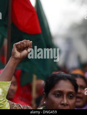 Dhaka, Bangladesh. 27th December 2013 -- A garment worker looks on during a protest following the arrest thirteen people charged over Tazreen factory fire by High Court where 112 worker had died. -- Tazreen garments worker & National Garmenta worker federation made protest rally in front of press club following the arrest thirteen people charged over Tazreen factory fire by High Court where 112 worker had died. Credit:  zakir hossain chowdhury zakir/Alamy Live News Stock Photo