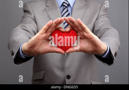 Businessmen is holding out a red heart Stock Photo