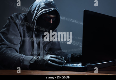 Hacker stealing data from a laptop Stock Photo