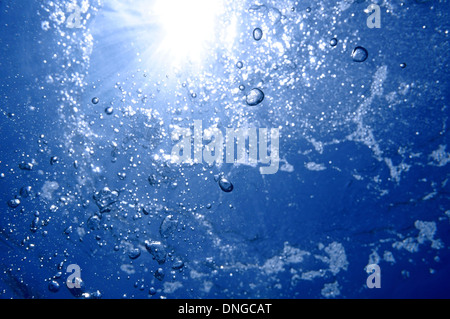Under water air bubbles rising to water surface with sunlight in background, natural scene, Caribbean sea Stock Photo