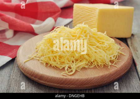 Grated cheese on wooden cutting board closeup Stock Photo