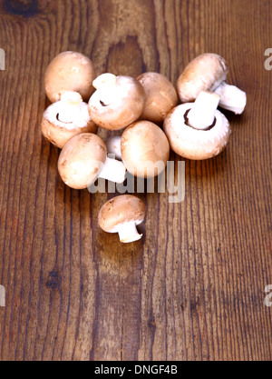 Brown champignons on wood background, vertical Stock Photo