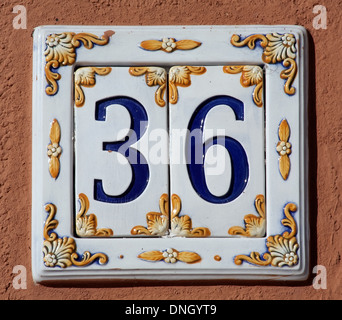 closeup of decorated house number digits sign on the wall Stock Photo
