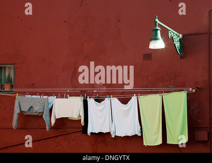 washing clothes on the rope closeup on the wall background Stock Photo