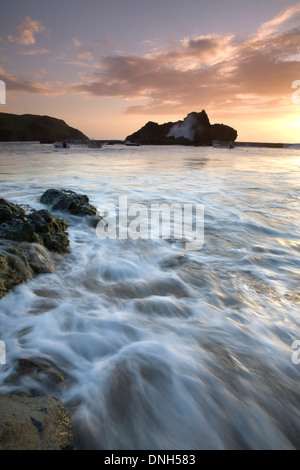 The tide rushes in through the harbour at Hope Cove, Devon, England, at sunset. Stock Photo