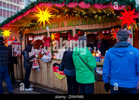 Shoppers visiting a booth selling German Christmas lights and decorations at Vancouver's outdoor Christmas Market, 2013. Stock Photo