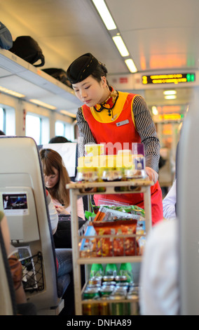 Drinks and snacks service trolley and server aboard a Chinese high speed train. Stock Photo