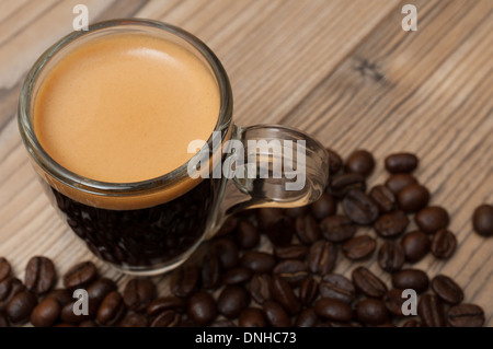 Glass Cup of Espresso Coffee on Wooden Table With Coffee Beans - Shallow Depth of Field Stock Photo