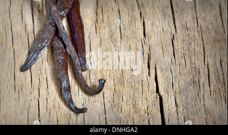 Bourbon vanilla beans isolated on wooden background Stock Photo