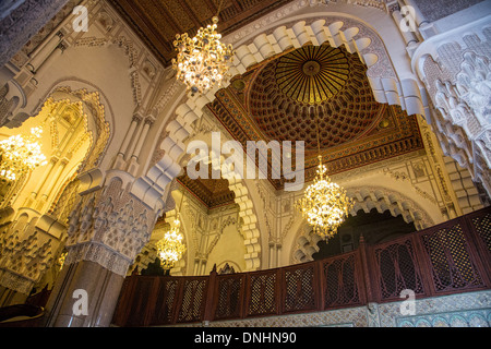 SCULPTED WOOD, STUCCO AND MARBLE CEILING INSIDE YOUTHS MEETING UP IN FRONT OF THE GREAT THE HASSAN II MOSQUE PARTLY ERECTED OVER THE SEA IN ARAB-ANDALUSIAN TRADITION, CASABLANCA, MOROCCO, AFRICA Stock Photo