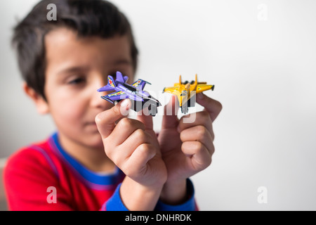 Boy plays with two toy aeroplanes Stock Photo