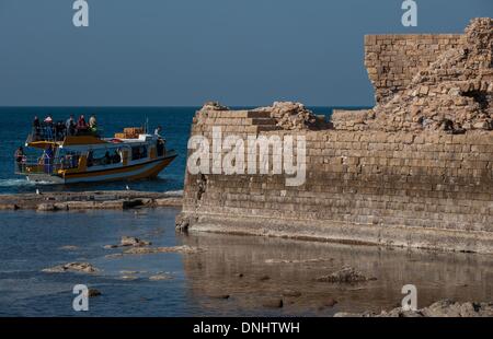 (131231) -- ACRE, Dec. 31, 2013 (Xinhua) -- A boat passes the remains of the Old City of Acre, northern Israel, on Dec. 27, 2013. The Old City of Acre in Acre in Israel was inscribed on the UNESCO World Heritage List in 2001. With a history of more than 5,000 years recorded in documents, Acre is a walled port-city with continuous settlement from the Phoenician period. The present city is characteristic of a fortified town of the Ottoman dating from 18th and 19th centuries, with typical urban components such as the citadel, mosques, khans and baths. The remains of the Crusader town, dating from Stock Photo