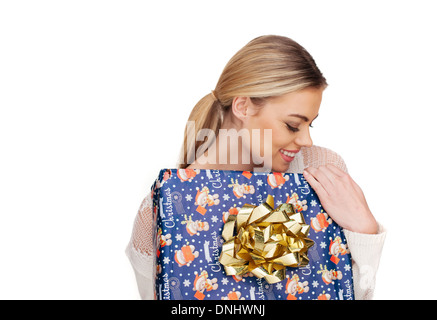 Young woman holds a gift wrapped in christmas paper, isolated on white Stock Photo