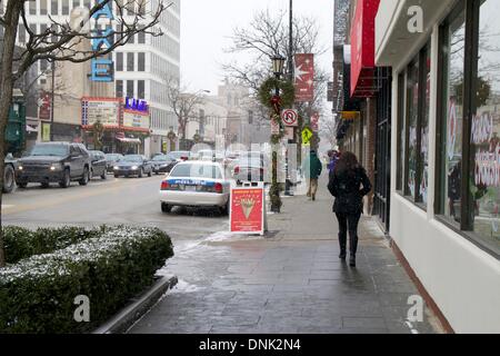 Oak Park, Illinois USA. 31st December 2013. Pedestrians hurry along Lake Street as snow starts to fall. The forecast calls for 3-5 inches to fall overnight with additional lake effect snow New Year's Day as winds shift and blow in from Lake Michigan. Credit:  Todd Bannor/Alamy Live News Stock Photo