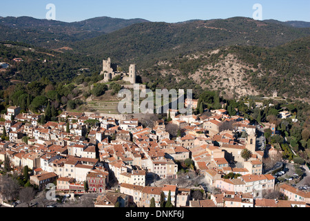 AERIAL VIEW. Perched abandoned medieval castle overlooking the old hillside village. Grimaud, Var, French Riviera, France. Stock Photo