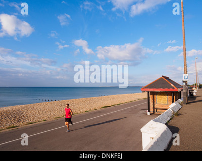 Man jogging by the sea along the quiet seafront promenade in Aldwick, Bognor Regis, West Sussex, England, UK, Britain Stock Photo