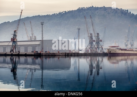 Industrial zone seaport with cranes in the fog Stock Photo