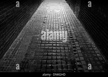 Cobbled alleyway backlit by light in South Woodford, London E18 Stock Photo