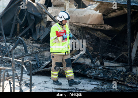 A fire investigator walks through the scene of a fire. Stock Photo
