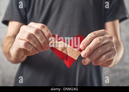 Broken hearted man. Valentines day concept. Man holding broken heart in his hands Stock Photo