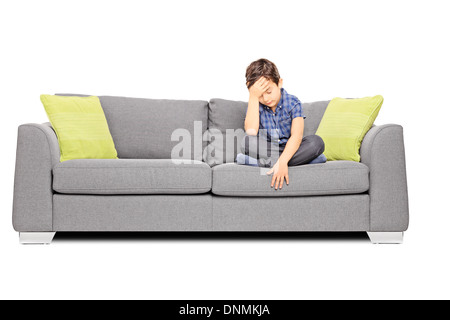 Sad boy sitting on a couch Stock Photo