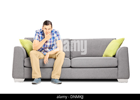 Worried young businessperson sitting on a modern sofa Stock Photo