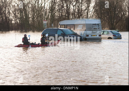 Yalding, Kent, UK. 2nd January 2014. The Environment Agency has issued a flood warning for Yalding Village in County of Kent the first one for 2014 on Thursday 2nd January.  Carpark at Hampstead lane and sunken cars with canoeists exploring new waterways Credit:  Yon Marsh/Alamy Live News Stock Photo