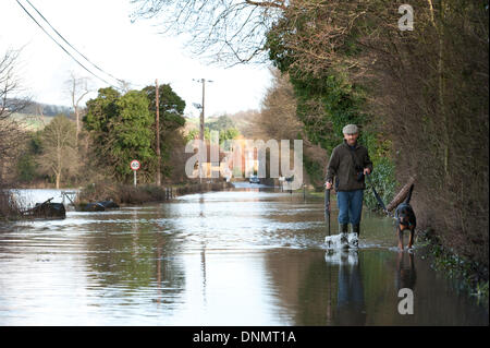 Yalding, Kent, UK. 2nd January 2014. The Environment Agency has issued a flood warning for Yalding Village in County of Kent the first one for 2014 on Thursday 2nd January. Lee Road the entrance to the Village with dog owner braving the path and flooded road Credit:  Yon Marsh/Alamy Live News Stock Photo