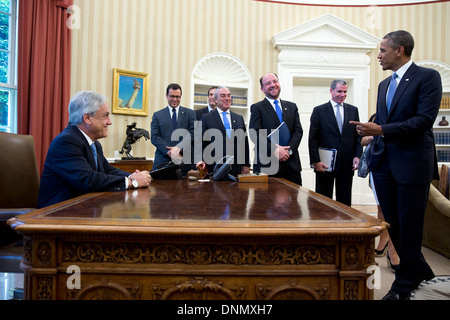 US President Barack Obama jokes with President of Chile Sebastion Pinera as he sits at the Resolute Desk in the Oval Office of the White House June 4, 2013 in Washington, DC. Stock Photo
