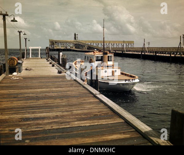 A pilot boat is docked near the phosphate elevator in Boca Grande, Florida, highlighting the local maritime industry, which was key to transporting phosphate during the 1940s. Stock Photo