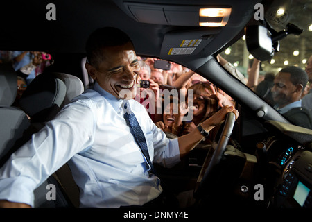 US President Barack Obama smiles after being mobbed by Ford workers while sitting in a truck at the Ford Kansas City Stamping Plant September 20, 2013 in Liberty, Missouri. Stock Photo