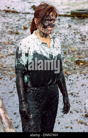 woman covered in filth during traditional game of mud football on langstone locks mud flats portsmouth england uk Stock Photo