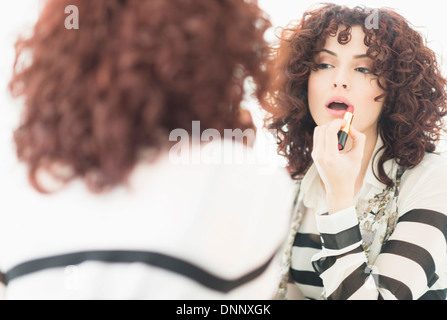 Beautiful brunette woman applying lipstick Stock Photo