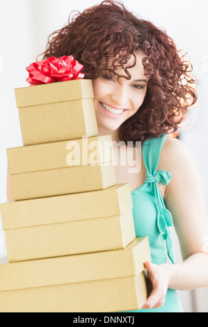 Woman holding stack of gifts Stock Photo