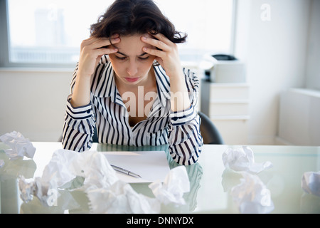 Overworked businesswoman sitting at desk Stock Photo
