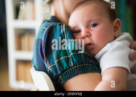 Baby girl (2-5 months) being embraced by mother Stock Photo