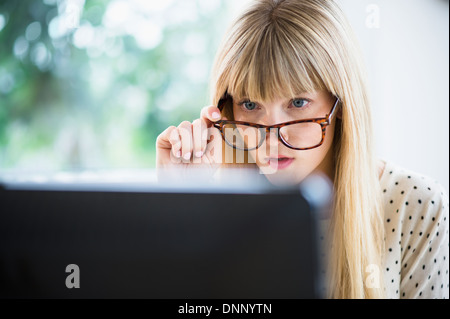 Woman wearing glasses working on computer Stock Photo