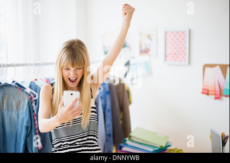 Woman looking at cell phone and cheering Stock Photo