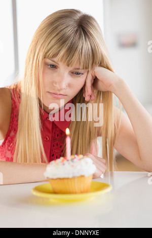 Woman looking at birthday cupcake Stock Photo