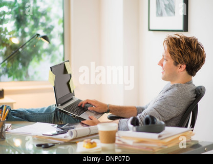 Man using laptop in home office Stock Photo