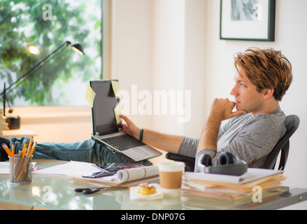 Man using laptop in home office Stock Photo