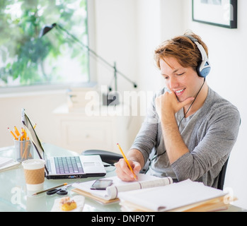 Man multi-tasking in home office Stock Photo