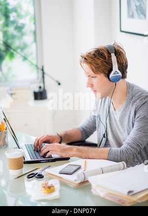 Man multi-tasking in home office Stock Photo