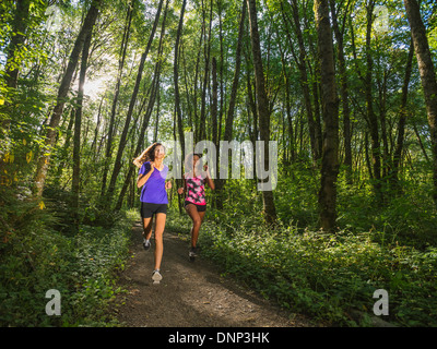 USA, Oregon, Portland, Two young women jogging in forest Stock Photo