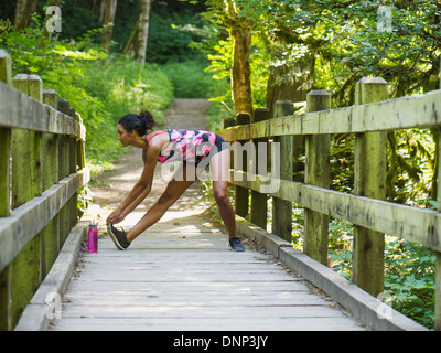 USA, Oregon, Portland, Young women stretching on footbridge Stock Photo