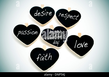 some heart-shaped blackboards with different words written on them related to love concept, such as respect or passion, and the Stock Photo
