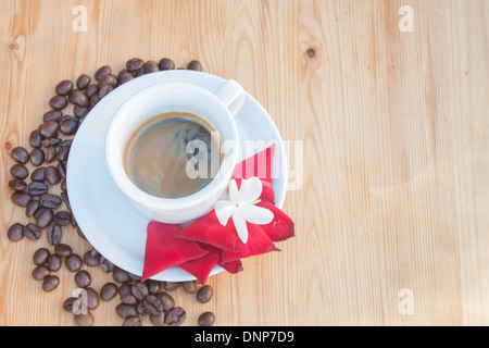 coffee beans cup closeup jasmine rose petals red wooden background nobody 'top view' Stock Photo